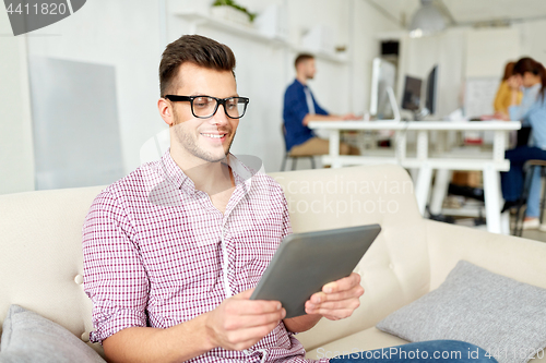 Image of man in glasses with tablet pc working at office