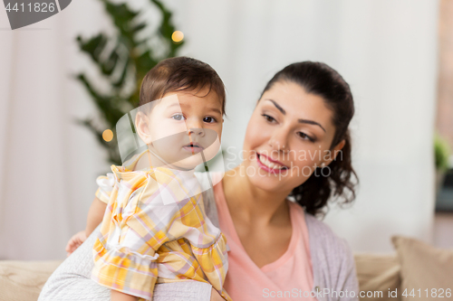 Image of happy smiling mother with baby daughter at home