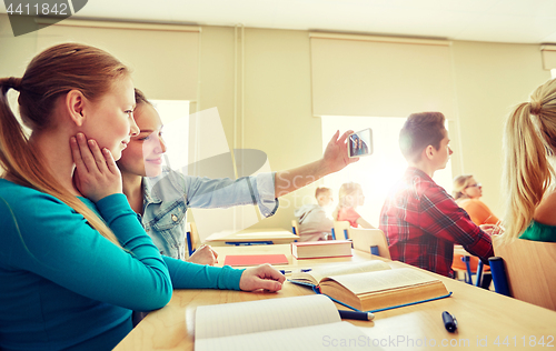 Image of student girls taking smartphone selfie at school