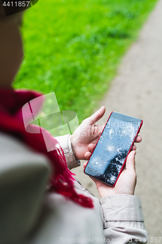 Image of Person holding broken smartphone