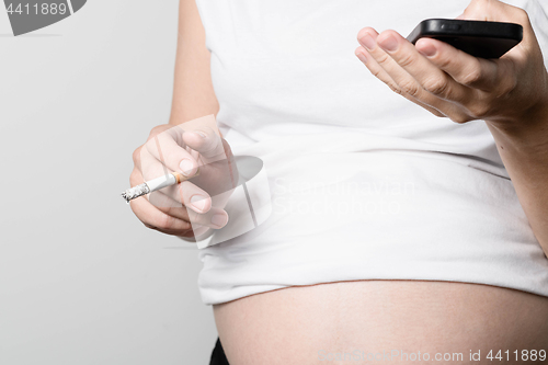 Image of Pregnant woman smoking cigarette.