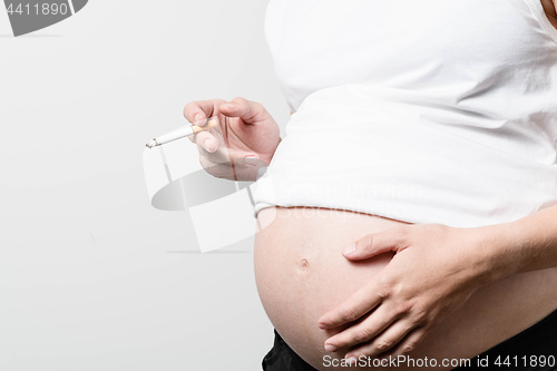 Image of Pregnant woman smoking cigarette.