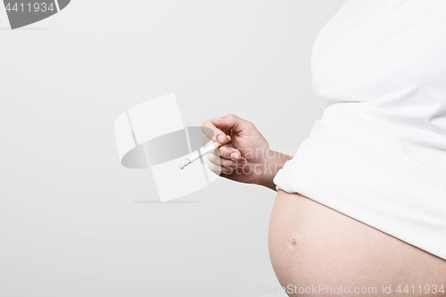 Image of Pregnant woman smoking cigarette.