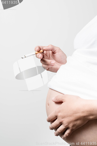Image of Pregnant woman smoking cigarette.
