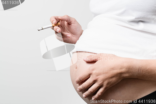 Image of Pregnant woman smoking cigarette.