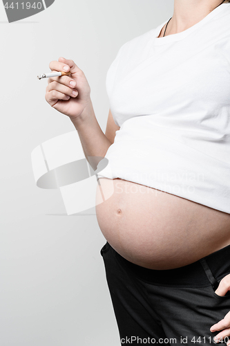 Image of Pregnant woman smoking cigarette.