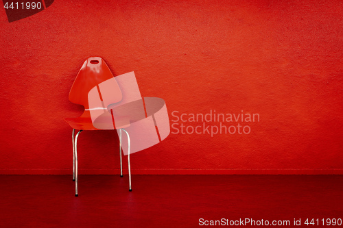 Image of red chair at a red wall with space for your content