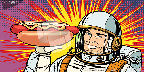 Image of Smiling male astronaut presents hot dog sausage
