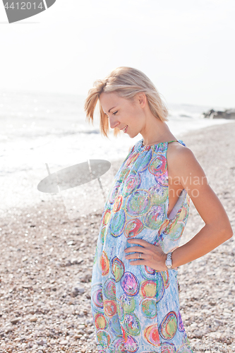 Image of Young blond woman in summer blue dress