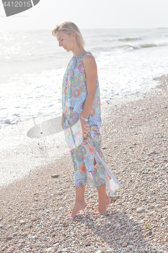 Image of Young blond woman in summer blue dress 