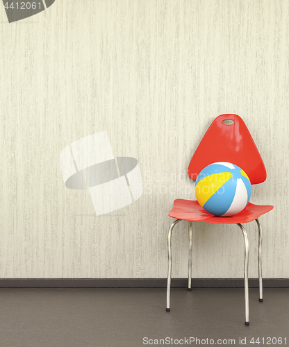 Image of red chair at a wall with a ball