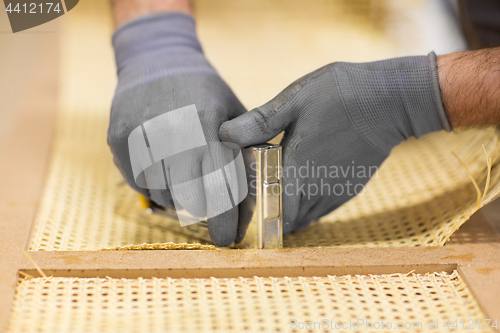 Image of assembler with staple gun making furniture