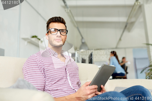 Image of man in glasses with tablet pc working at office