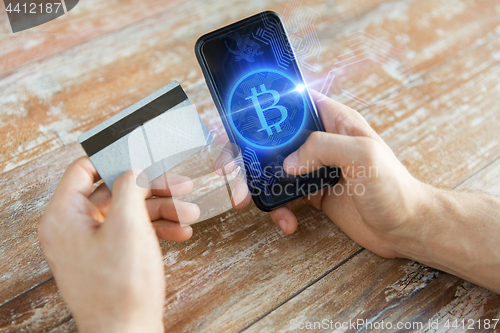 Image of close up of bitcoin on smartphone and credit card