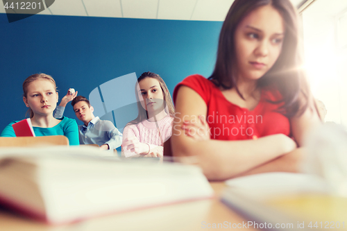 Image of students gossiping behind classmate back at school