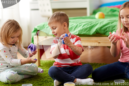 Image of little kids with modelling clay or slimes at home