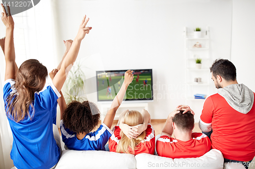 Image of friends or soccer fans watching game on tv at home