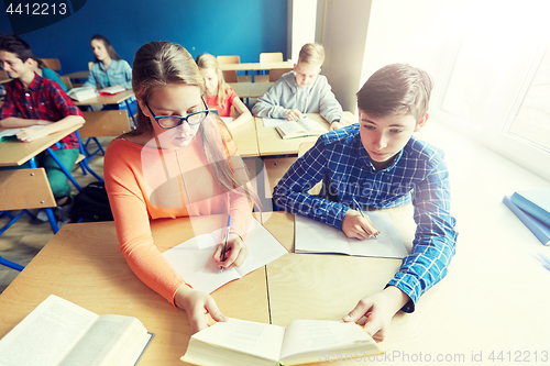 Image of students reading book at school lesson