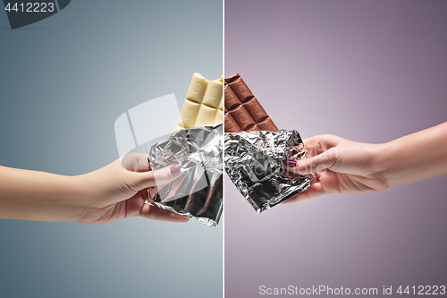 Image of Hands of a woman holding a tile of chocolate