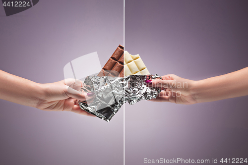 Image of Hands of a woman holding a tile of chocolate