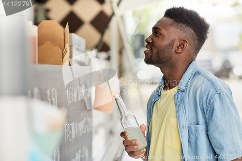 Image of african american man with drink at food truck