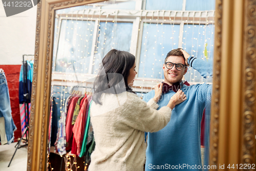 Image of couple choosing bowtie at vintage clothing store