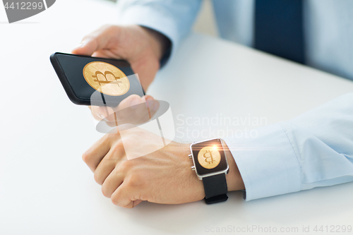 Image of close up of bitcoin on smartphone and smart watch