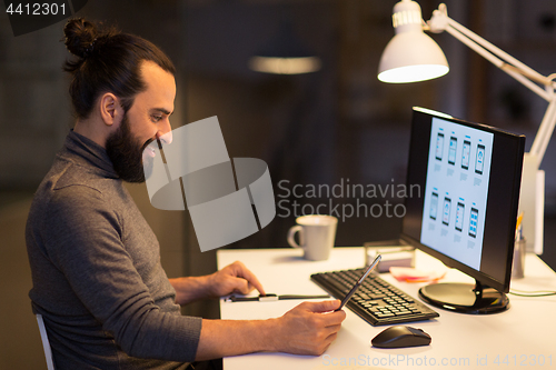 Image of man with smartwatch and tablet pc at night office