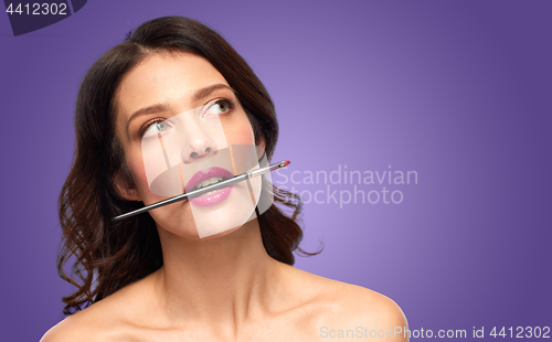 Image of beautiful woman with make up brush for lipstick