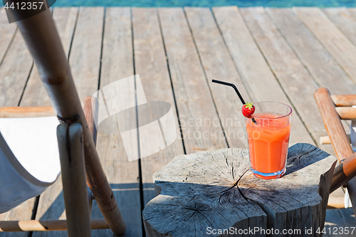 Image of Wooden floor with chaise-longues and cocktail