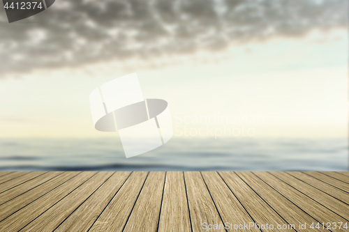 Image of wooden jetty with blurred ocean background