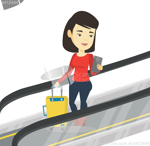 Image of Woman using smartphone on escalator in airport.