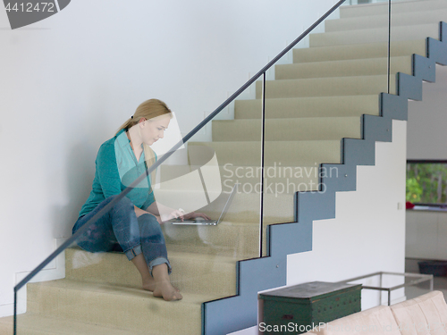 Image of portrait of a young beautiful woman on the stairs