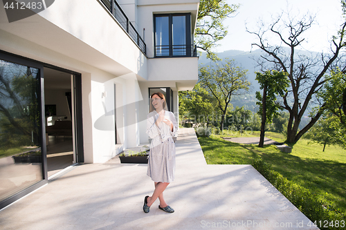 Image of woman in a bathrobe enjoying morning coffee