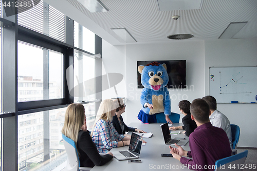 Image of boss dresed as bear having fun with business people in trendy of