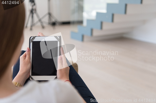 Image of woman sitting on sofa with tablet computer