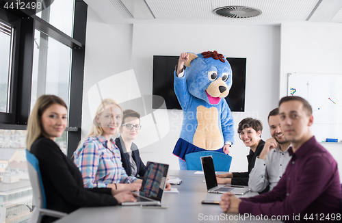 Image of boss dresed as bear having fun with business people in trendy of