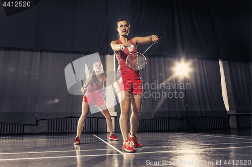 Image of Young women playing badminton at gym