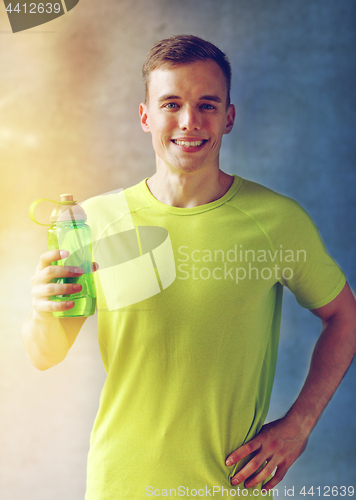 Image of smiling man with bottle of water in gym