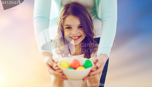 Image of close up of girl and mother holding easter eggs