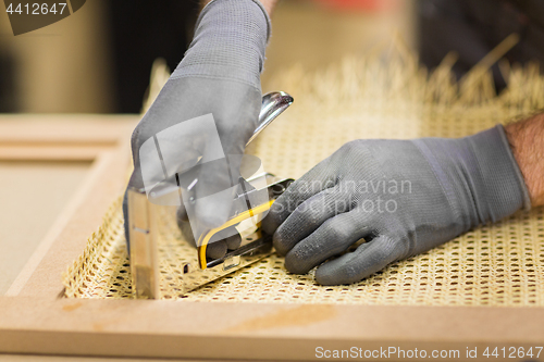 Image of assembler with staple gun making furniture