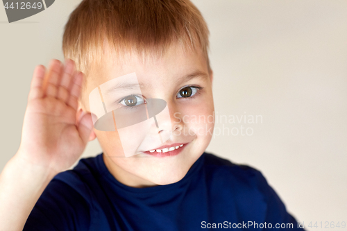 Image of portrait of happy smiling little boy waving hand