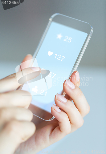 Image of hands with social media icons on smartphone