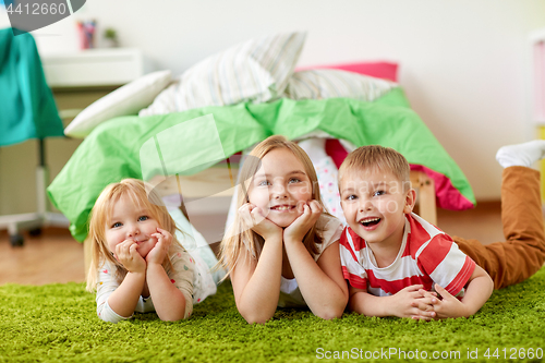 Image of happy little kids lying on floor or carpet