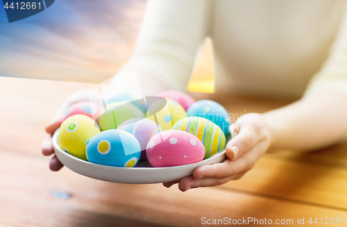 Image of close up of woman hands with colored easter eggs