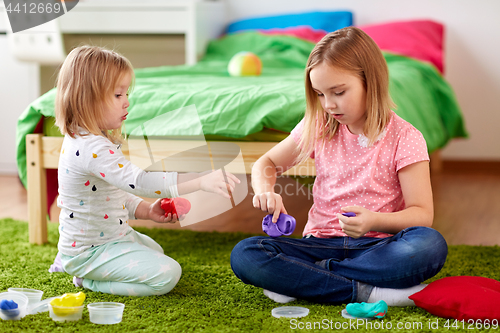 Image of sisters with modelling clay or slimes at home