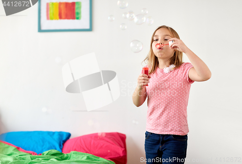 Image of girl blowing soap bubbles at home