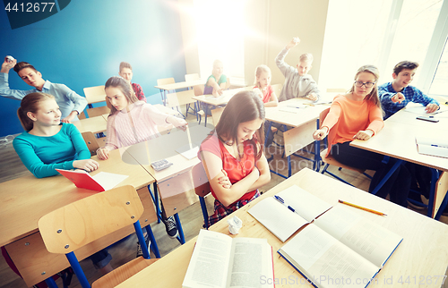 Image of students gossiping behind classmate back at school