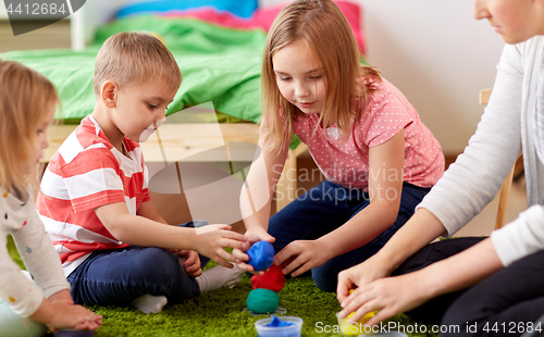 Image of kids and mother with modelling clay or slimes