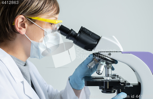 Image of Scientist looking through a microscope